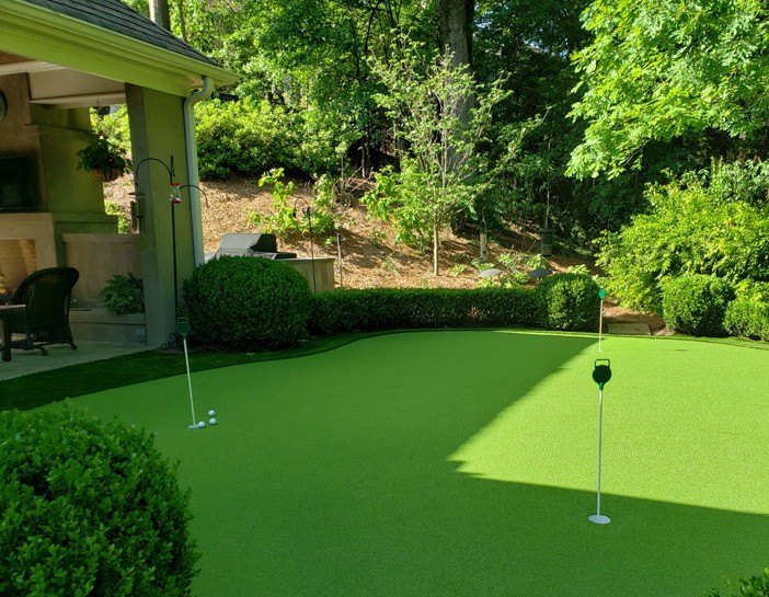Residential short-game chipping green built beside a covered patio